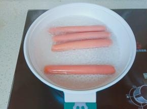 帝伯朗焕彩陶瓷不粘煎锅加一碗清水煮开，水开放入火腿肠煮一分钟。