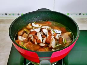 加入纯净水，再加入切好的香菇，盖上盖子烧开，转小火将排骨炖烂。