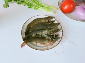 准备活蹦乱跳的新鲜对虾一份、番茄、洋葱、香菜，鱿鱼去软骨、去外衣再切圈 