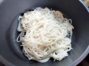 锅里再倒一些油，倒入晾干水的米粉，翻炒一会，可以用筷子辅助。