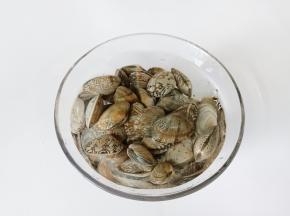 花蛤放入清水里，加食用、盐浸泡2小时左右，让花蛤将泥沙吐干净。

