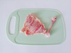 用刀在鸡腿根部剪一下，用剪刀沿着鸡腿上肉把骨头取下来。