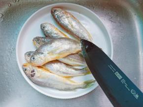 用刀从鱼尾往上把鱼鳞刮掉。