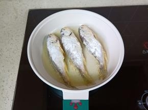 锅里放上适量的食用油，油微热放入小梅鱼，开中火慢慢煎。