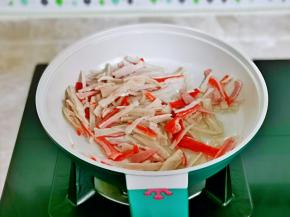 起油锅，加入蟹柳丝翻炒。