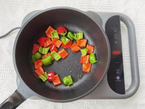 8、锅重新清洗干净，擦干，倒入适量油，开火热油后，倒入青红椒块，翻炒到青红椒断生。