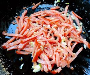 锅中倒入底油加热放入蒜粒爆香再放入香肠丝炒出香味