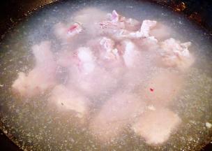 锅中烧开水放入排骨同时倒入料酒焯水断生去除多余的油脂和杂质