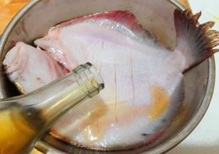 多宝鱼的腹部割几刀不要割断倒入料酒按摩入味