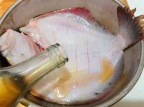 多宝鱼的腹部割几刀不要割断倒入料酒按摩入味