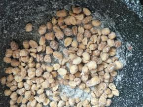 关火后放入花生米翻炒，随着温度降低花生米会挂满糖霜。