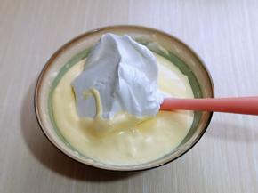 再取三分之一的蛋白霜加入蛋黄糊中，继续上面的手法，翻拌直至看不到蛋白霜。