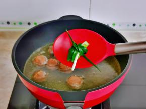 小葱去皮洗净，卷起来烧开转小火将丸子煮熟。