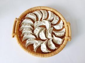 去一勺馅料放在饺子皮上面包起来。