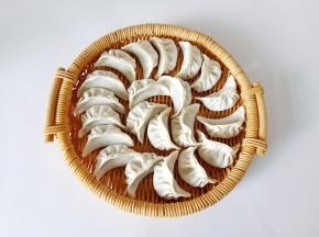 去一勺馅料放在饺子皮上面包起来。