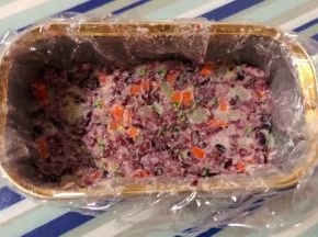 保鲜膜先放入午餐肉盒中再取适量拌好的时蔬双米饭压实