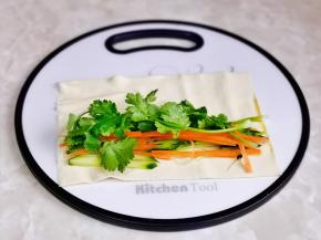 取一张豆皮，放上香菜，胡萝卜丝与黄瓜丝。