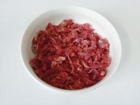 把切好的牛肉丝放入碗里。