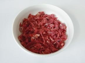 把切好的牛肉丝放入碗里。