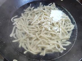 烧一锅水，水开后，加1汤匙玉米油，然后下面条。最好分开撒，然后用锅铲抄下底，防止沉底糊锅。在水再次煮沸后，加一碗凉水，盖上锅盖等再次煮开，注意不要溢锅。可以用筷子夹一根试试能不能夹断，能夹断就好了，夹不断就再煮一会。