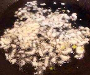 锅中倒入底油加热放入蒜粒爆香