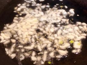 锅中倒入底油加热放入蒜粒爆香