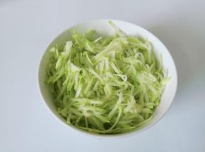 西葫芦削皮，用擦丝板擦成丝，捏紧去除多余的水份。