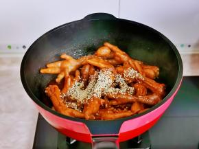 鸡爪炖烂后，大火收汁撒上熟白芝麻翻炒均匀，关火出锅。