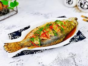 取出蒸好的鱼，撒上葱丝，辣椒丝，再淋上热油。