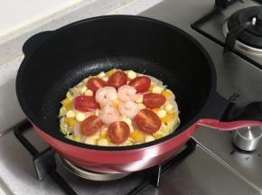 然后把甜椒和洋葱撒在面条饼上，再把小番茄和鸡肉肠摆上去，然后放上虾仁。