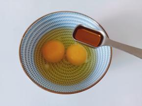 碗里放两个鸡蛋，加料酒一勺、细盐适量。