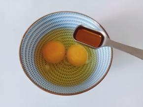 碗里放两个鸡蛋，加料酒一勺、细盐适量。