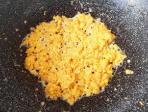 不粘锅里继续倒入少许食用油烧热，倒入蛋黄，快速滑炒定型。