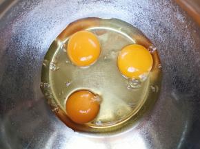 鸡蛋磕入打蛋盆里。 