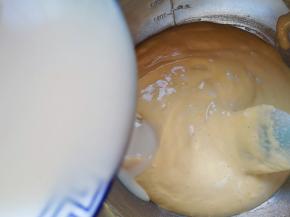 顺着盆边加入混合好的牛奶和玉米油。