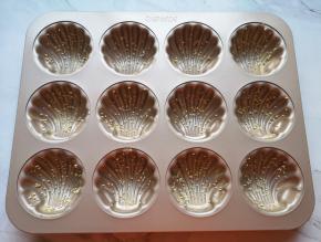 玛德琳模具里面抹上一层黄油，撒上熟白芝麻。