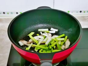 加入香菇片与蒜白，煸炒出香味儿。