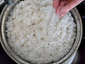 蒸好的糯米在自来水下冲凉。