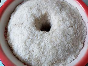 用饭勺将糯米压平整，中间掏一个洞。将剩下的酒曲均匀地撒在表面。