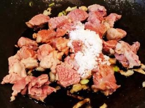 另起锅放入底油加热放入葱蒜爆香放入羊肉和调味料一品鲜酱油、糖