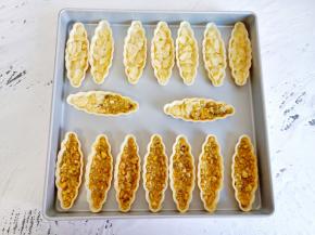 准备16个糯米船，把放凉的馅料勺子舀一点在糯米船，铺平即可，加太多烤的时候要溢出来【这里做了两种口味，所以用了32个糯米船】