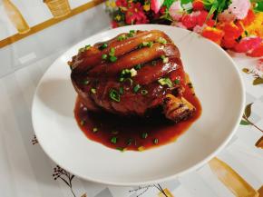 把肘子拿出来放入盘中，淋上刚熬好的芡汁儿，撒上适量的葱花即可!