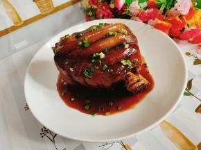 把肘子拿出来放入盘中，淋上刚熬好的芡汁儿，撒上适量的葱花即可!