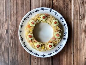 把黄瓜切成片，红花型的模具压出小花的形状，小米辣切成小段，坐小花的花心，然后把小花摆到花环炒饭上即可。