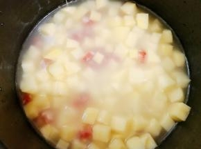 加入土豆丁搅拌均匀，电饭煲选择精华煮程序，煮好跳到保温后继续焖8分钟