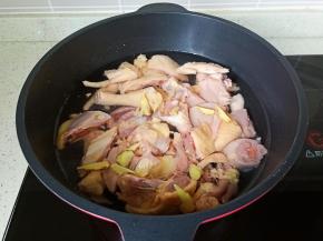 三黄鸡冷水下锅加生姜片、清水没过三黄鸡。