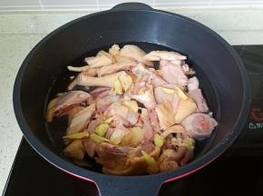 三黄鸡冷水下锅加生姜片、清水没过三黄鸡。