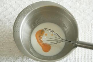 步骤2、玉米油和牛奶倒入干净盆中，用蛋抽搅打至乳化，看不见油点。加入所有蛋黄。