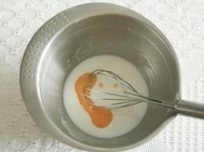 步骤2、玉米油和牛奶倒入干净盆中，用蛋抽搅打至乳化，看不见油点。加入所有蛋黄。