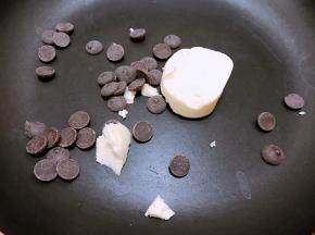 平底锅里加入黄油和黑巧克力，最小火加热至融化
